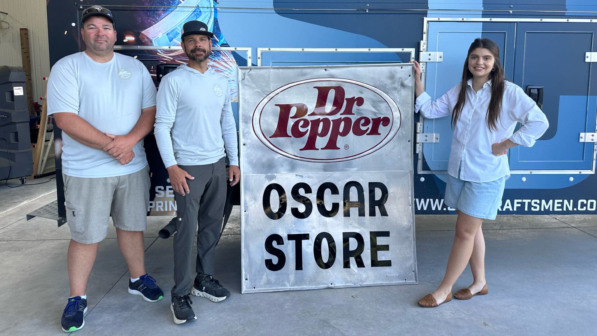 Casual team posing beside vintage soda sign
