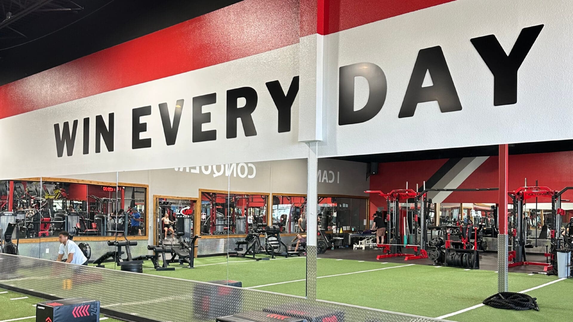 Red and black weight racks by mirrors