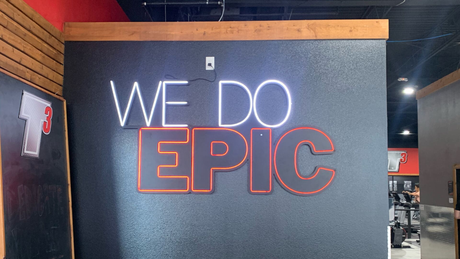 Neon sign reading WE DO EPIC on wall