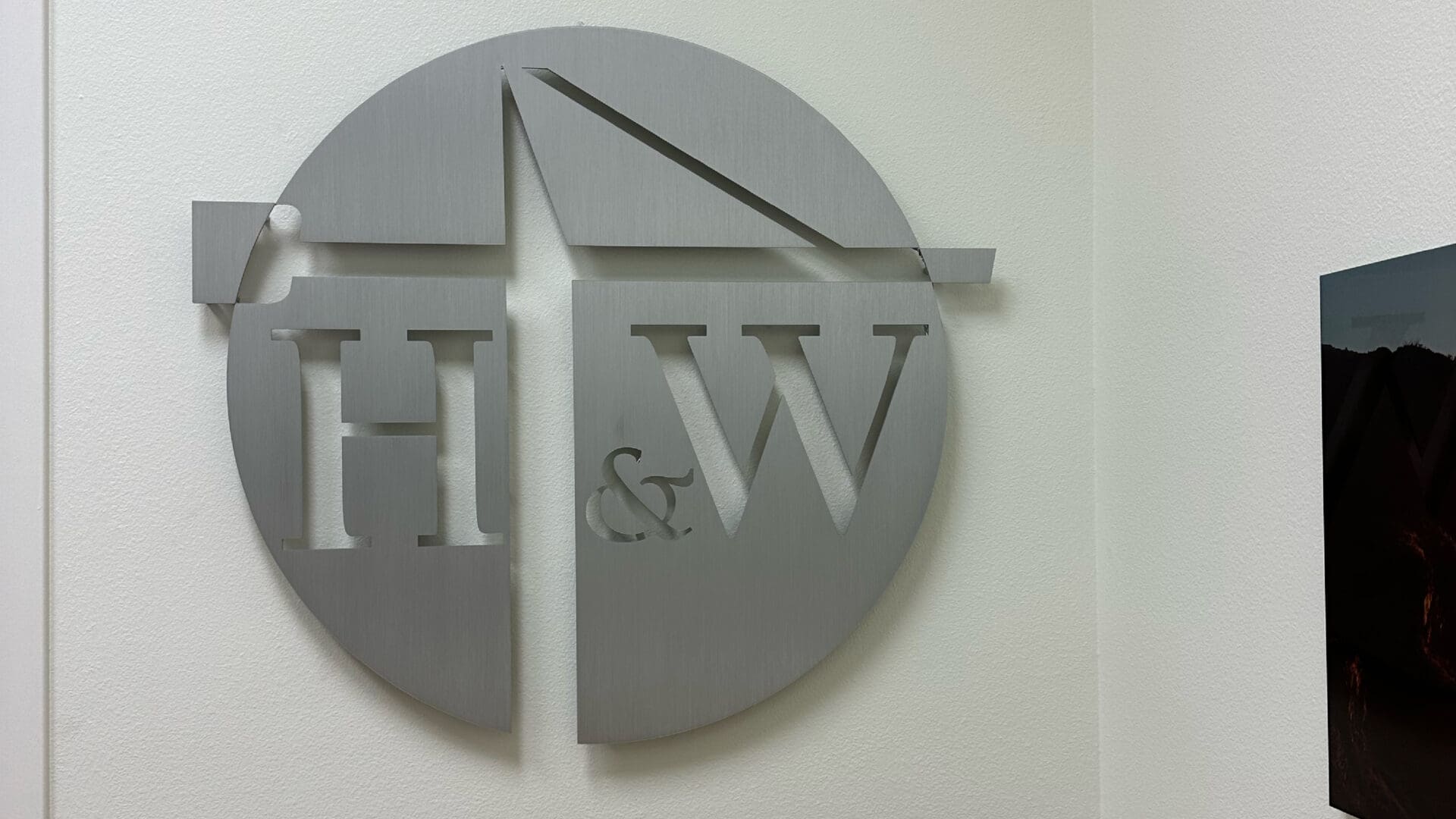Brushed metal H & W circular wall logo