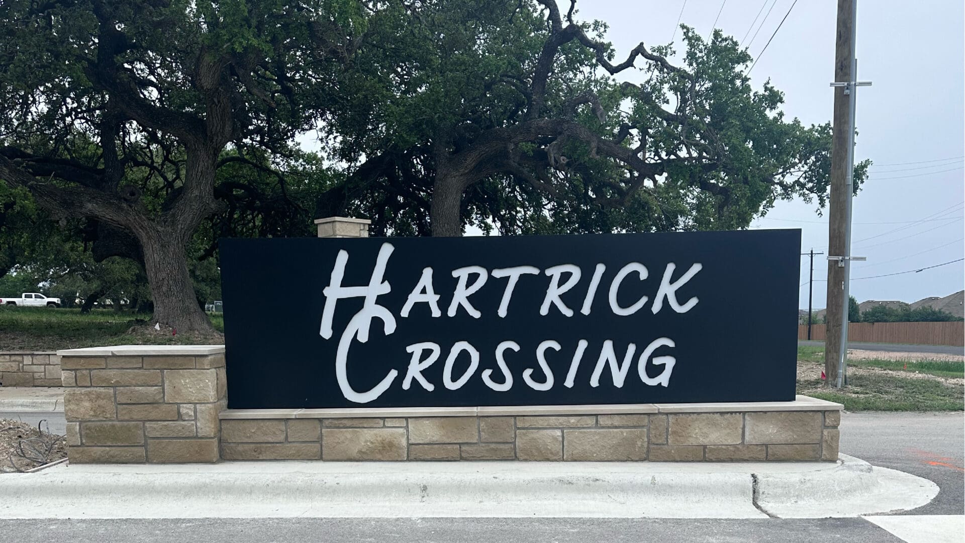 Hartrick Crossing entrance sign with oak tree