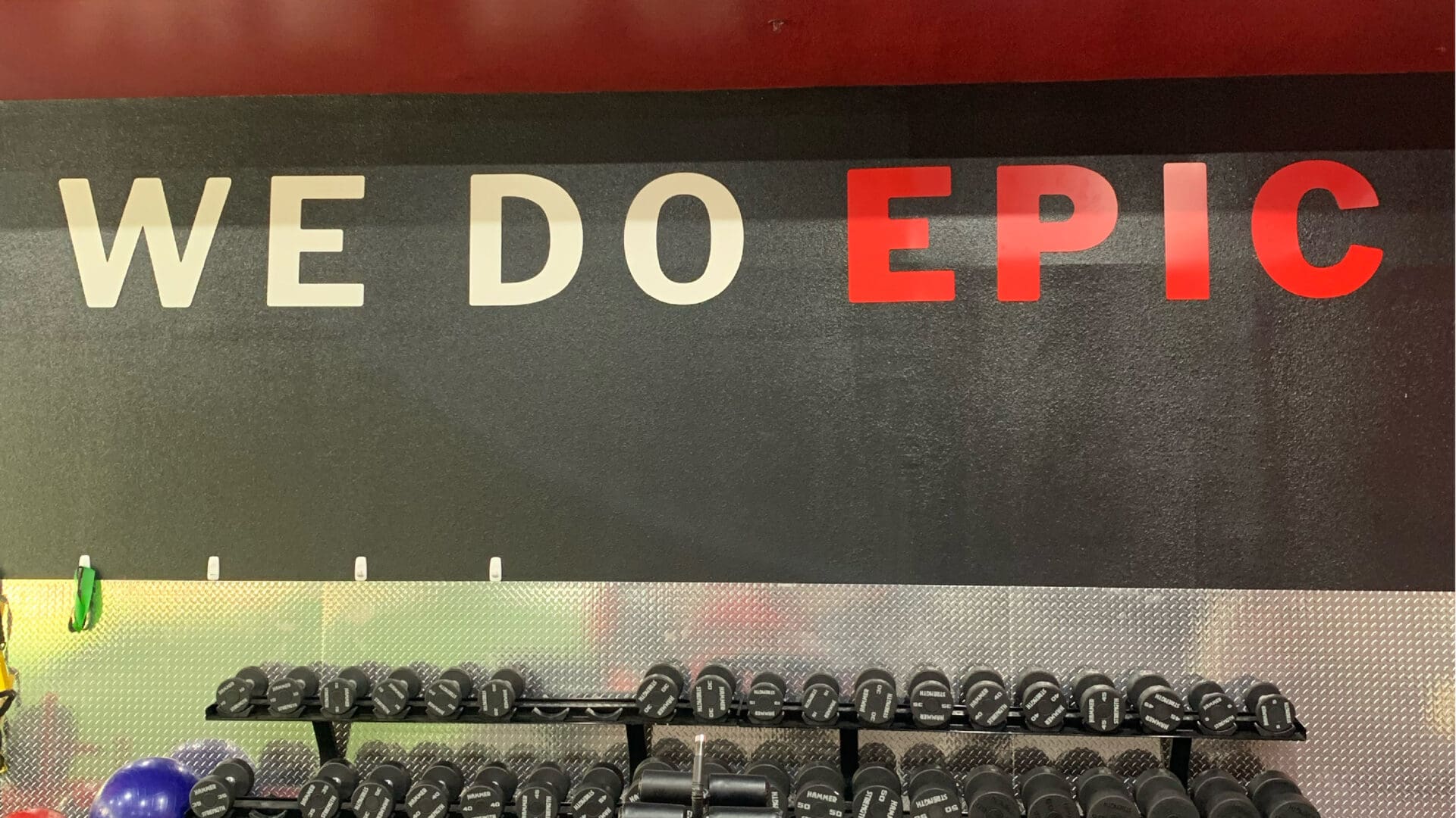 Dumbbell rack under WE DO EPIC wall sign
